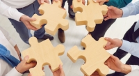 image of 4 people holding large puzzle pieces symbolizing balance